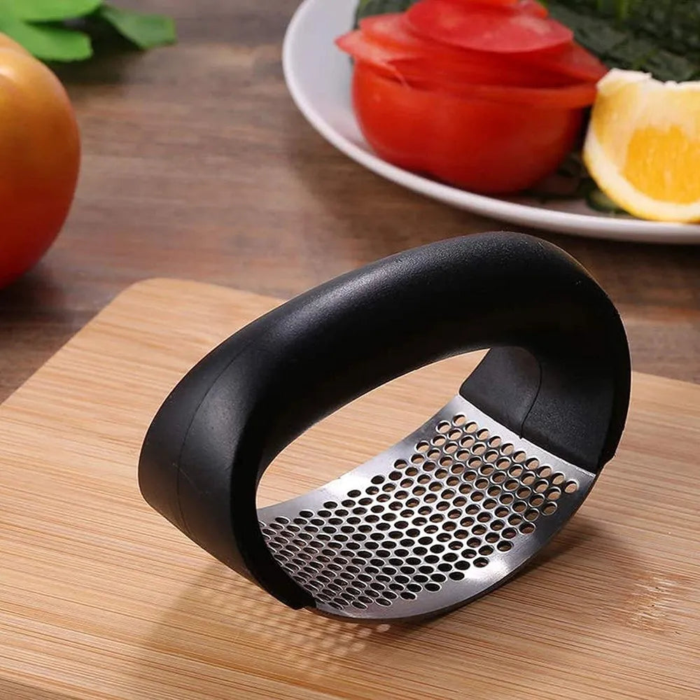 Black handheld grater on a wooden surface with fruits in the background