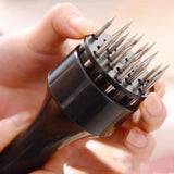 Black hair dryer with metallic spikes held by a hand against a blurred background