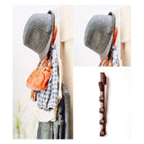 Gray bonnet, orange bag, and plaid shirt hanging on a wooden rack against a white background.