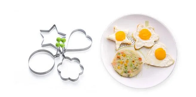 Metal cookie cutters shaped like stars, hearts, and flowers on a white plate with flower-shaped cookies.