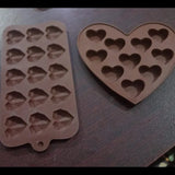 Two silicone molds with heart shapes on a dark surface