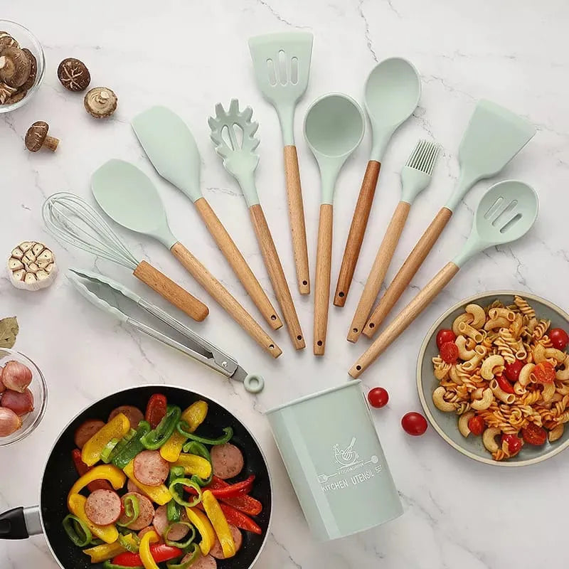 Set of green and brown kitchen utensils on a marble surface with food items.