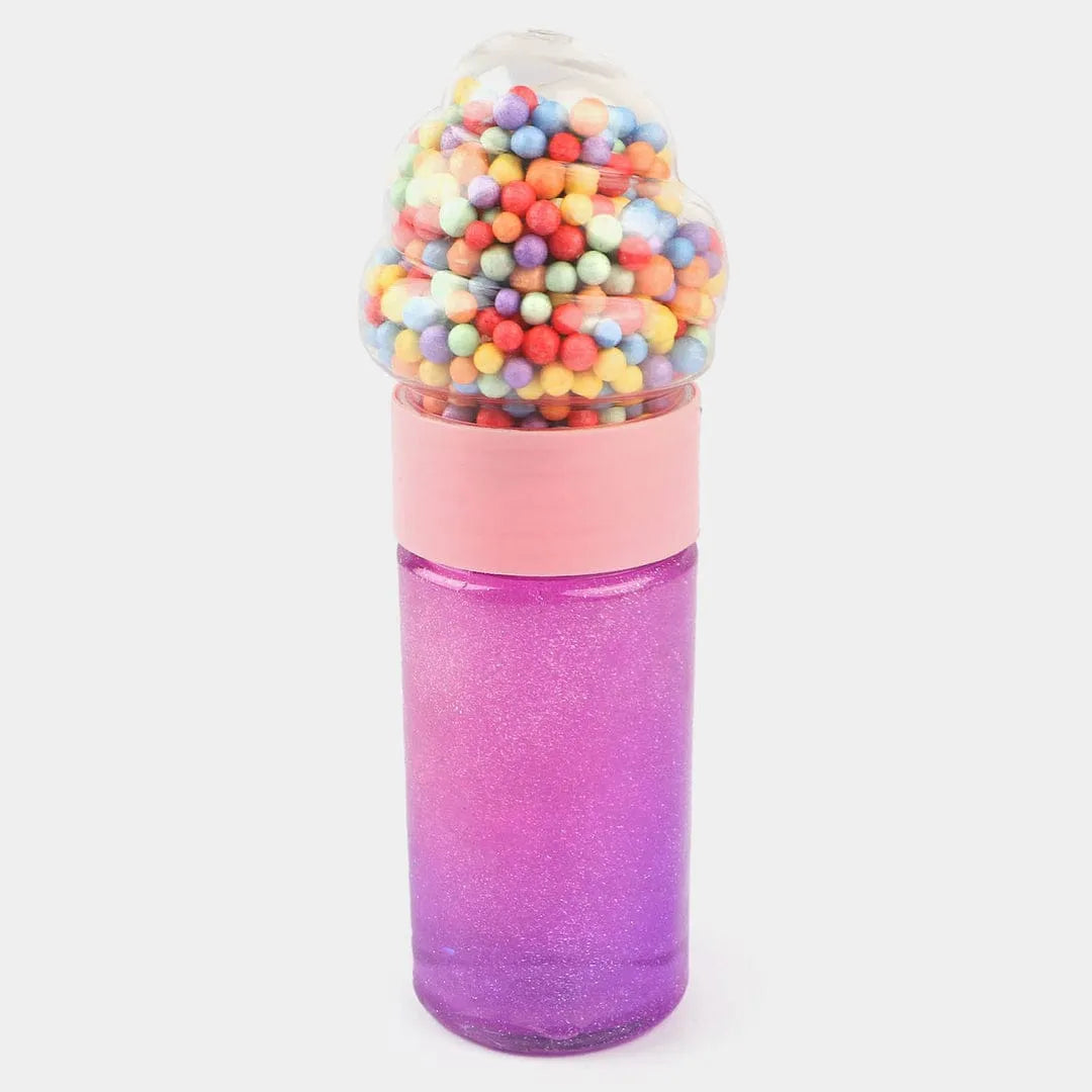 A novelty bottle shaped like a gumball machine, with a glittery purple-to-pink gradient body, a light pink collar, and a clear top filled with multicolored gumball-like beads, shown on a light gray background.