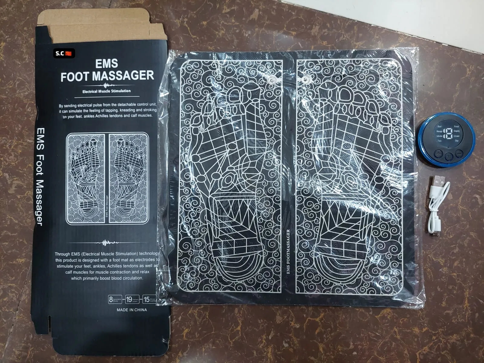 Portable electric foot massage mat with EMS and TENS functions for convenient home and travel use.