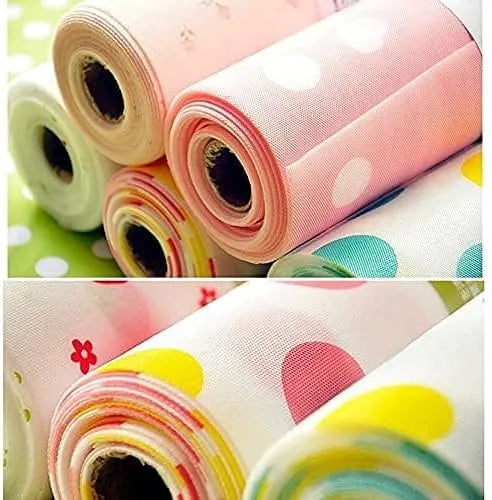 A collage of fabric rolls with pastel patterns, including pink with white polka dots, white with yellow polka dots, and white with pink and yellow floral prints.