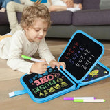 Child playing with a portable blackboard and markers on a wooden floor.