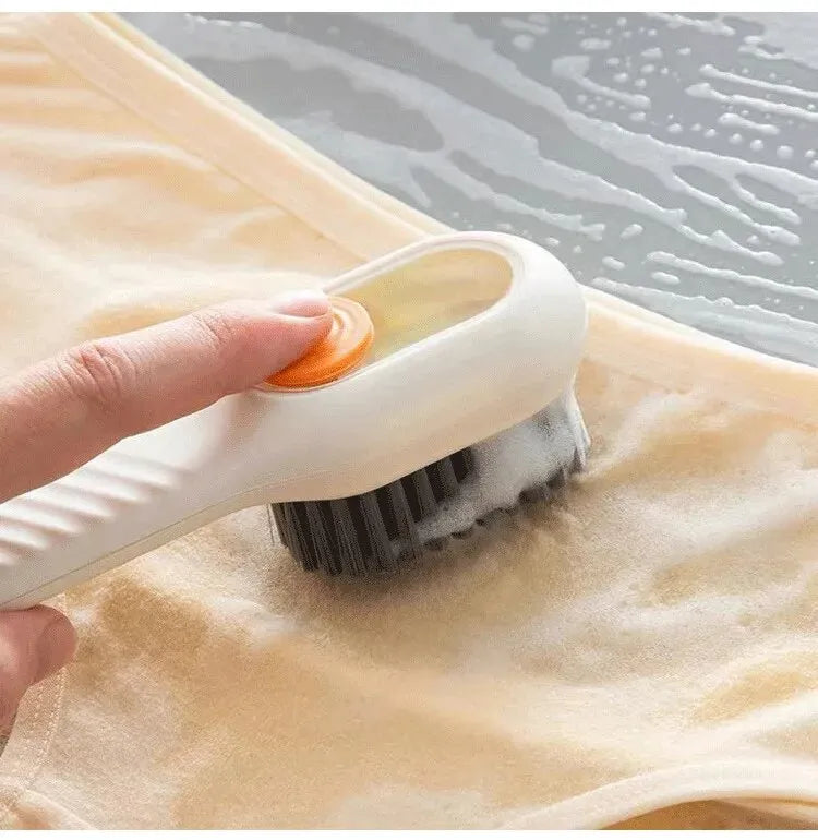 Person using a scrub brush on a piece of fabric with water in the background