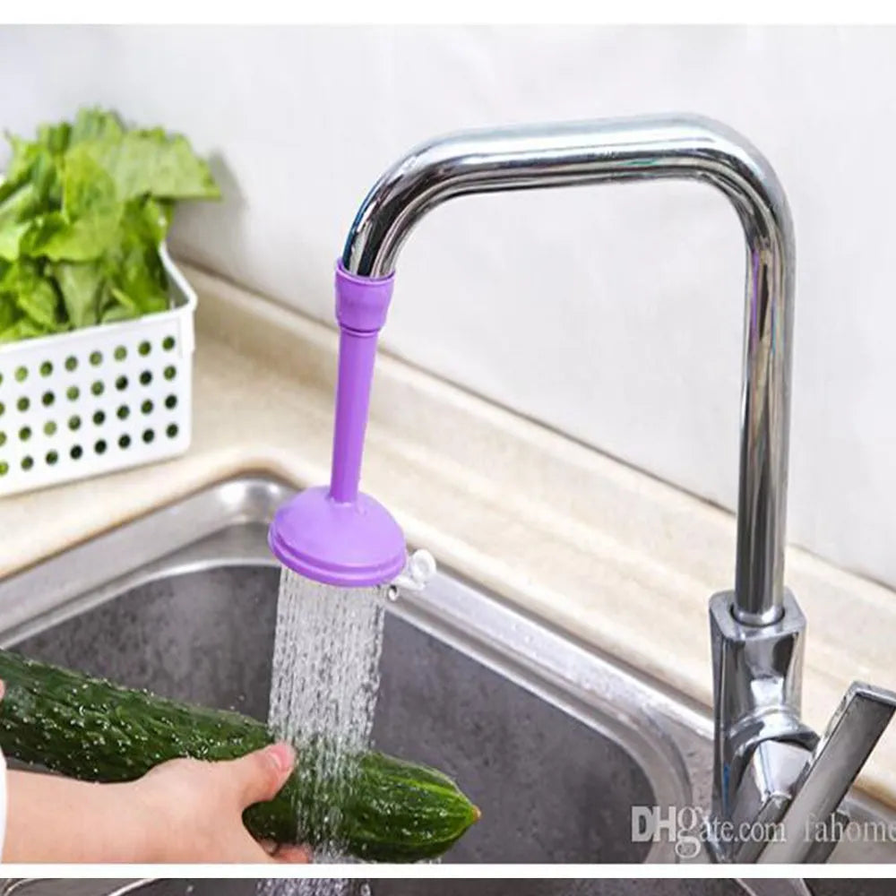 Purple faucet extension with water flowing over a cucumber in a kitchen sink.