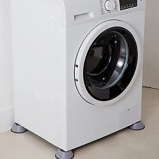 A white front-loading washing machine with gray feet, shown in a clean indoor setting with a light beige wall and floor.