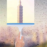 Hand holding a transparent object with a cityscape in the background