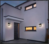 Modern house exterior with wall lights and a door at night.
