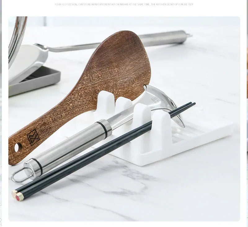 Wooden spoon and metal chopsticks on a white stand with a marble background