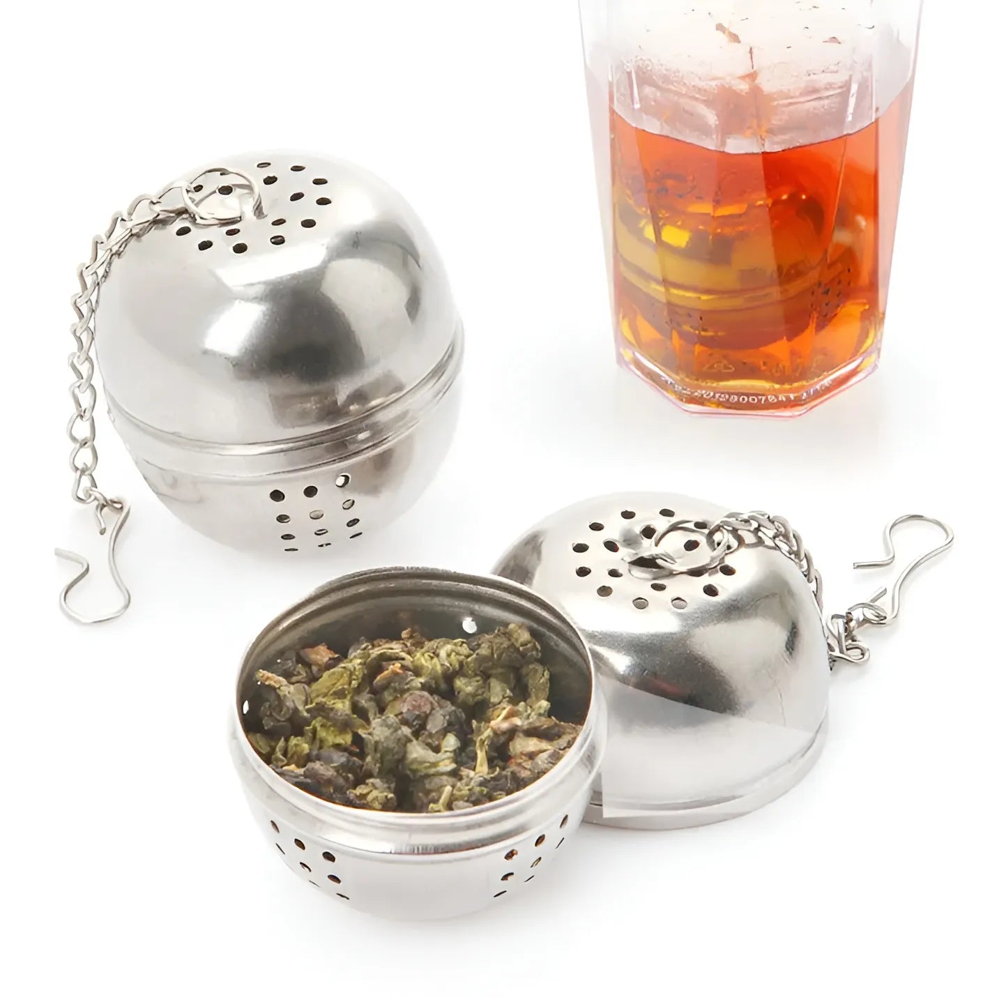 Metallic tea infuser with a glass of iced tea on a white background
