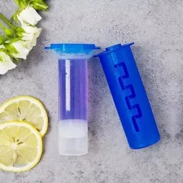 Blue shaker bottle with a purple and white container on a gray surface with lemon slices and flowers.