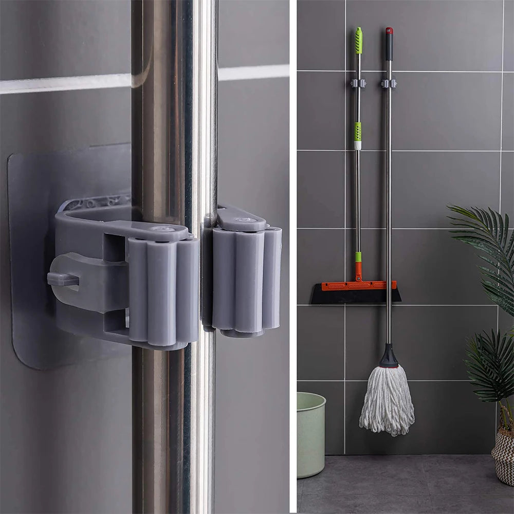 Gray wall-mounted cleaning tool holder attached to a shower door with cleaning tools in the background.